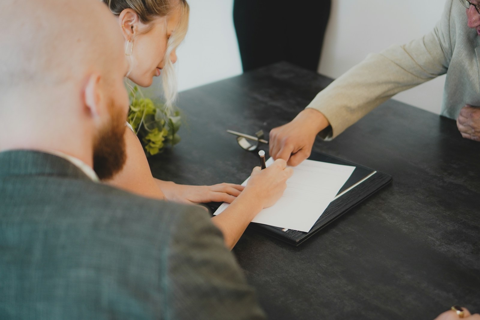 Couple signing a legal document with an advisor